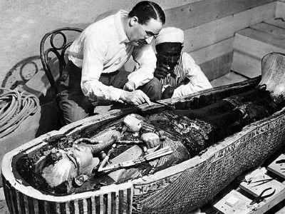 Howard Carter examinant la momie de Toutânkhamon dans son sarcophage – photographie historique de Harry Burton, découverte de la tombe KV62 