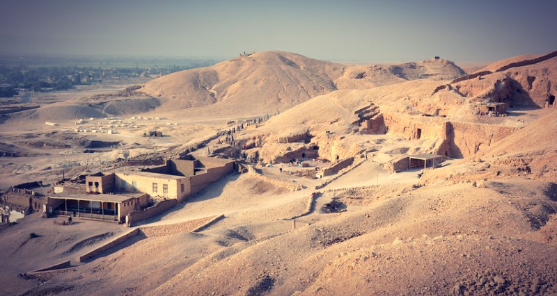 Vue panoramique de la colline de Cheikh Abd el-Gournah sur la rive ouest de Louxor, montrant le flanc sud de la nécropole où se trouve la tombe de Sennefer (TT96), dite "la tombe aux vignes", creusée dans la roche calcaire.