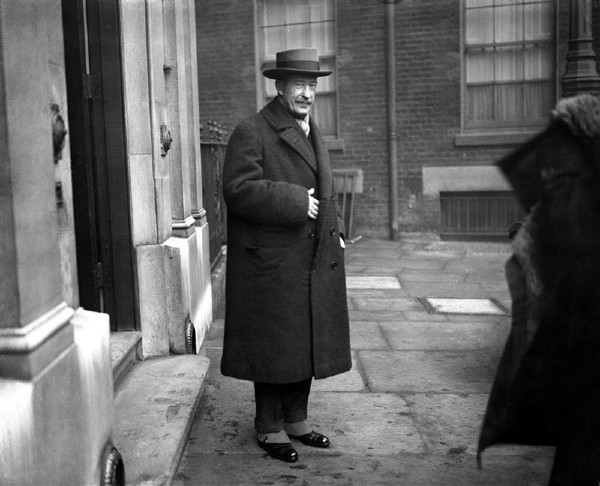 Photographie en noir et blanc de Lord Carnarvon, mécène de l'expédition archéologique, se dirigeant à la gare Victoria à Londres, prêt à embarquer pour l'Égypte après avoir appris la découverte du tombeau de Toutankhamon par Howard Carter en 1922.