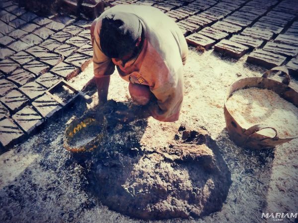 Un artisan égyptien préparant des briques de terre crue, matériau de construction traditionnel promu par Hassan Fathy.