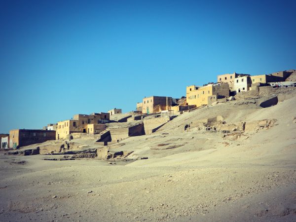 Vue actuelle du site de l'ancien village de Gourna à Louxor, montrant les vestiges des habitations et les tombeaux pharaoniques désormais protégés et mis en valeur.