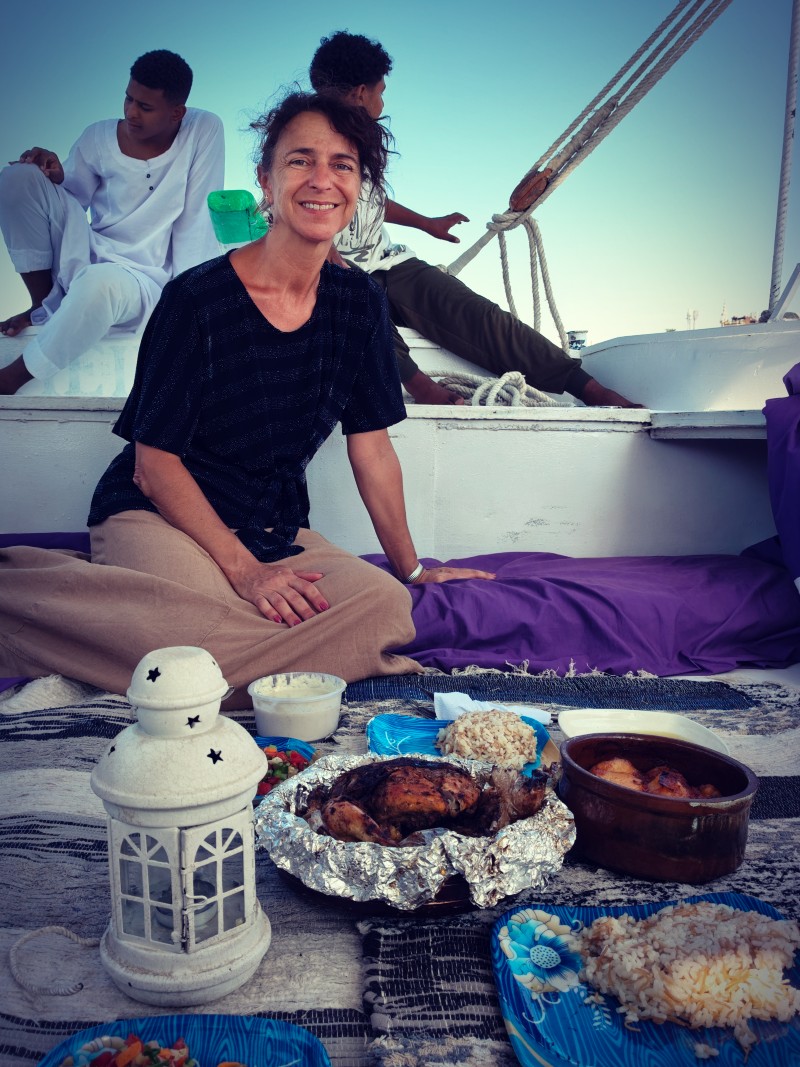voyageuse à LOuxor appréciant un repas traditionnel à bord d'une felouque