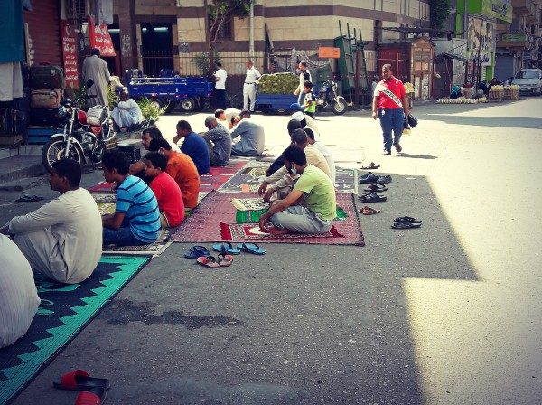 Fidèles musulmans écoutant prêche du vendredi assis sur tapis dans la rue devant mosquée Louxor Égypte