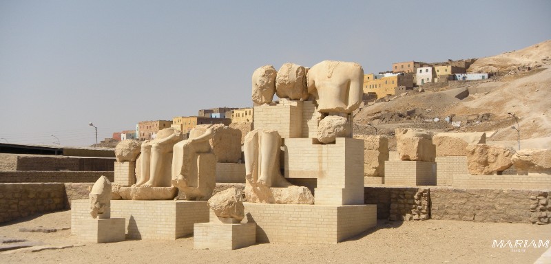 Statues de Mérenptah remontées et restaurées dans son temple funéraire, avec l'ancien village de Qurnah en arrière-plan, rive ouest de Louxor