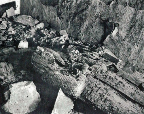 Photographie historique de la découverte de la tombe KV55 en 1907, montrant le sarcophage royal défiguré et la momie partiellement détruite, attribuée à Akhenaton ou Smenkhkarê.