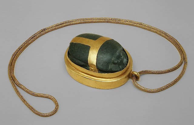 Scarabée de cœur en serpentinite et or d'Hatnefer, exposé au Metropolitan Museum of Art, représentant un scarabée au dos finement ciselé avec une chaîne en or tressé.