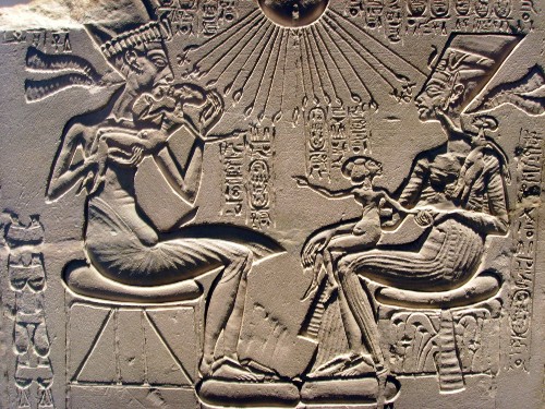 Stèle en calcaire de la période amarnienne représentant Akhenaton embrassant sa fille, assis en face de Néfertiti sous les rayons d'Aton – Neues Museum, Berlin.