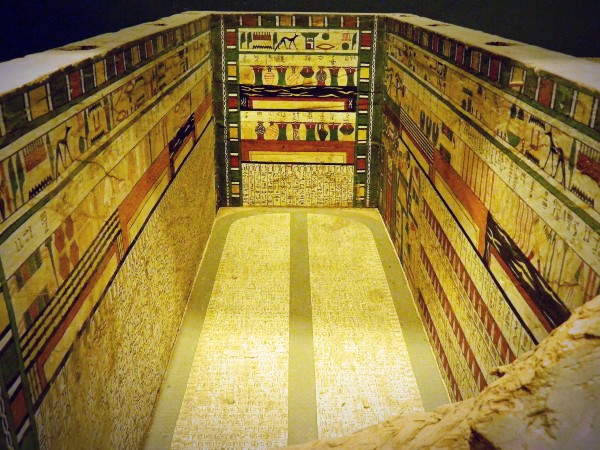 Photographie de la face interne d'un cercueil en bois du Moyen Empire exposé au Musée de Louxor, dont les parois intérieures sont entièrement décorées de Textes des Sarcophages en hiéroglyphes polychromes et de représentations d'équipement funéraire idéal .